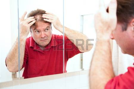 14943207-middle-aged-man-checking-for-thinning-hair-in-the-mirror.jpg