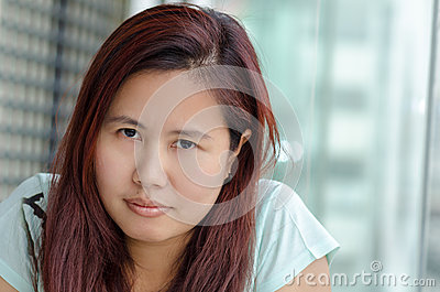 angry-asian-woman-portrait-who-sitting-next-to-window-glass-looking-to-camera-40061863.jpg