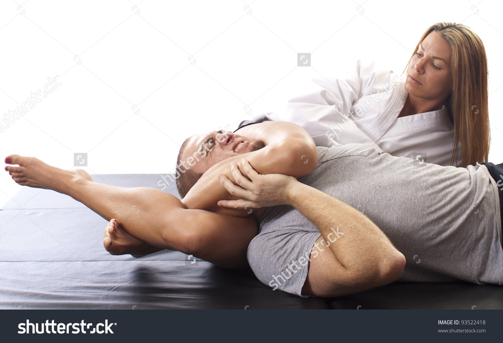 female-martial-artist-applying-a-figure-four-chokehold-against-an-opponent-on-black-mat-93522418.jpg