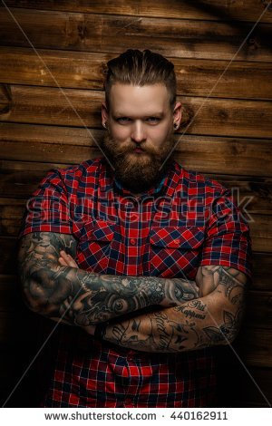 stock-photo-tattooed-bearded-male-in-a-red-shirt-posing-over-wooden-wall-in-a-studio-440162911.jpg