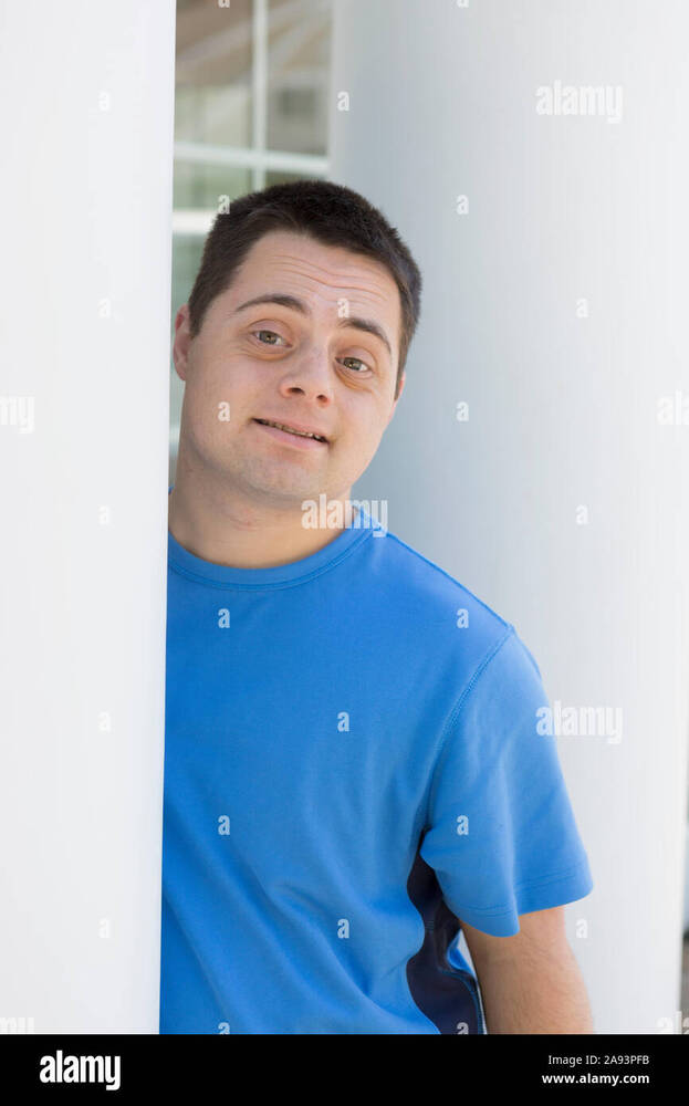 -with-down-syndrome-leaning-against-a-wall-2A93PFB.jpg