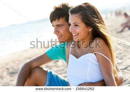 stock-photo-cute-teen-couple-sitting-together-on-beach-at-sunset-156841262.jpg